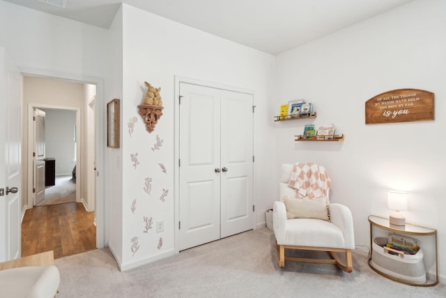 sitting room featuring light carpet