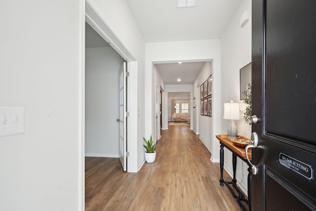 corridor with hardwood / wood-style flooring