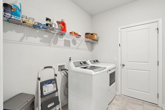 laundry room featuring light tile patterned floors and separate washer and dryer