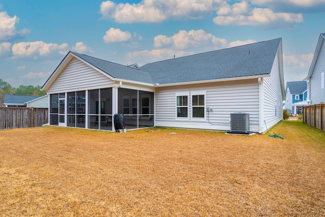 rear view of property featuring a sunroom, central AC unit, and a lawn