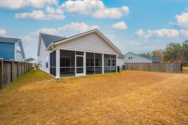 back of property featuring a sunroom, a yard, and central AC unit