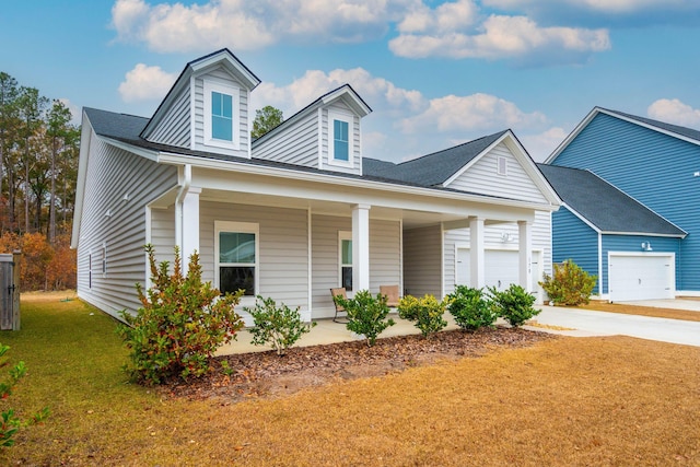 view of front facade featuring covered porch, a garage, and a front yard