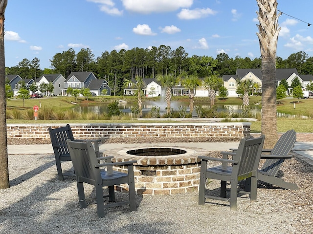 view of patio with a fire pit and a water view