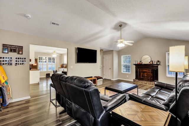 living room featuring a fireplace, lofted ceiling, ceiling fan, and dark hardwood / wood-style floors