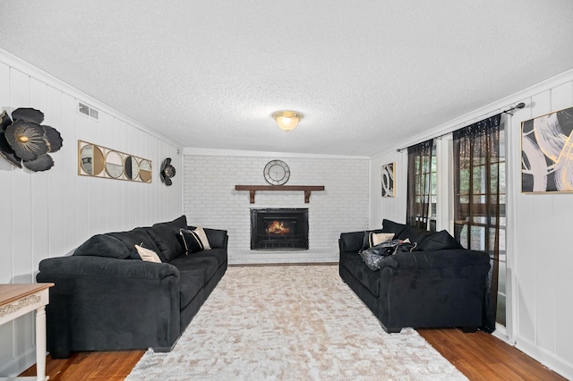 living room featuring a fireplace, crown molding, hardwood / wood-style floors, and wooden walls