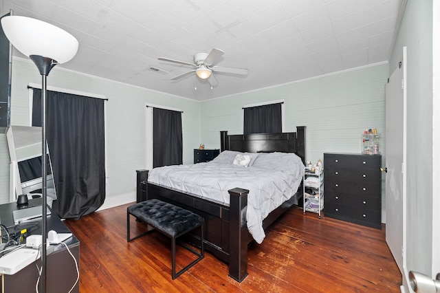 bedroom with ceiling fan, dark hardwood / wood-style floors, and ornamental molding