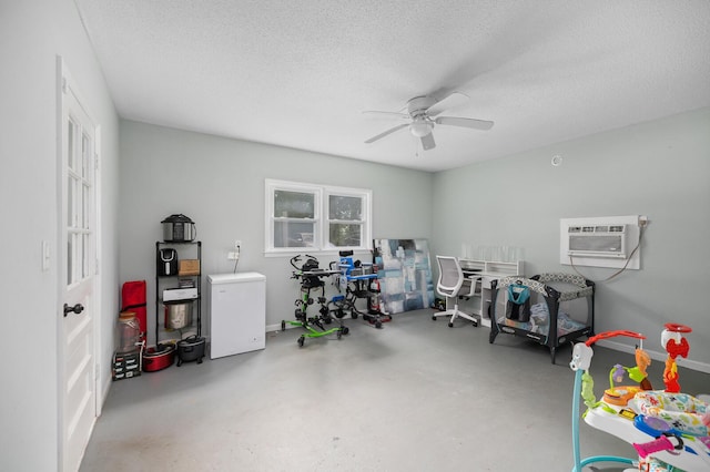 game room featuring ceiling fan, a wall mounted air conditioner, concrete flooring, and a textured ceiling