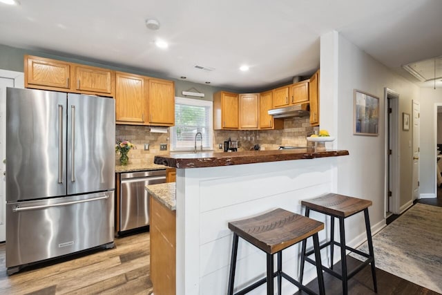 2158 Till Rd, Charleston, SC 29414 - kitchen featuring stainless steel appliances, under cabinet range hood, light wood-style flooring, backsplash, and recessed lighting