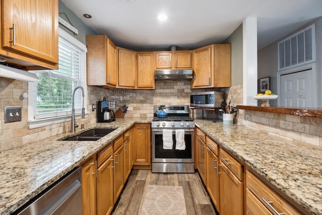 2158 Till Rd, Charleston, SC 29414 - kitchen with stainless steel appliances, under cabinet range hood, light wood-style floors, light stone counters, and backsplash
