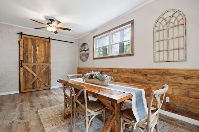2158 Till Rd, Charleston, SC 29414 - dining space featuring a barn door, wood finished floors, crown molding, brick wall, and a ceiling fan