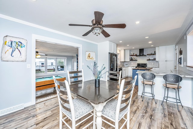 dining area featuring ceiling fan, light hardwood / wood-style floors, and ornamental molding