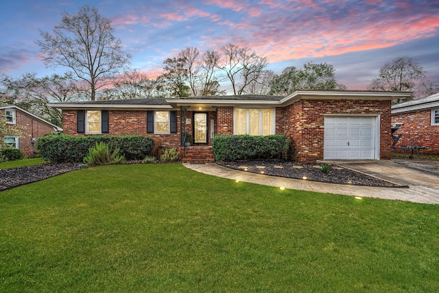 ranch-style house with a garage and a lawn