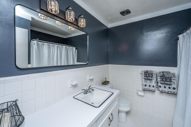 bathroom featuring tile patterned floors, vanity, tile walls, and toilet