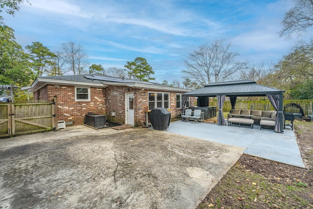 rear view of property with outdoor lounge area, a gazebo, a patio, and central AC unit