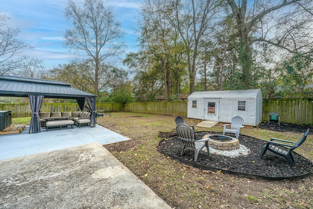 view of yard featuring a gazebo, an outdoor structure, a patio, and an outdoor living space with a fire pit