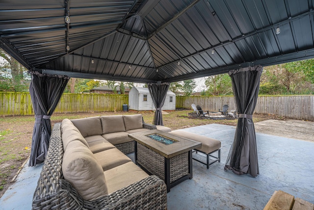 view of patio with a gazebo, a shed, and an outdoor living space with a fire pit