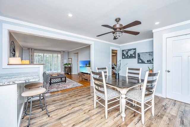 dining space with crown molding, ceiling fan, and light hardwood / wood-style floors