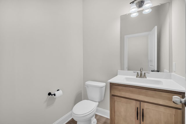 bathroom with vanity, wood-type flooring, and toilet