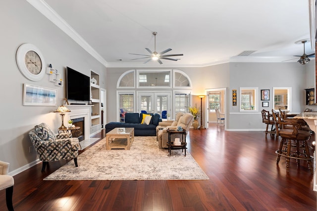 living room with dark hardwood / wood-style flooring, built in features, ceiling fan, and crown molding