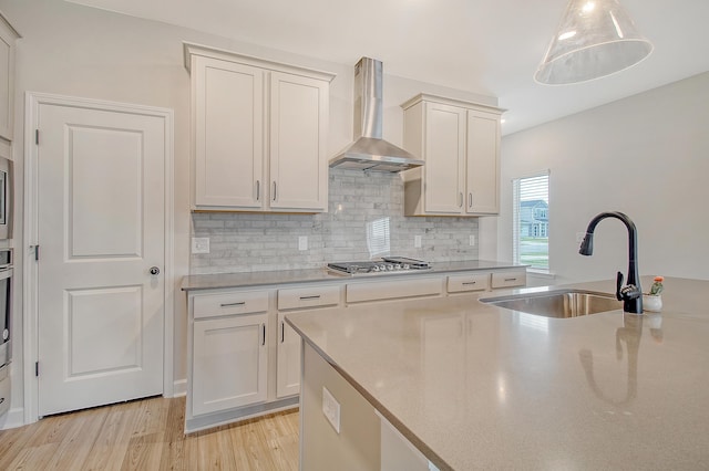 299 Lucca Dr, Summerville, SC 29486 - kitchen with wall chimney exhaust hood, appliances with stainless steel finishes, light wood-style flooring, backsplash, and light countertops