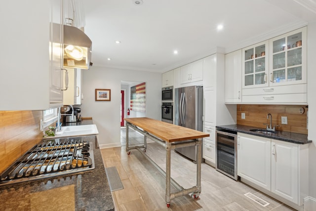 293 Grove St, Charleston, SC 29403 - kitchen with wine cooler, appliances with stainless steel finishes, a sink, backsplash, and crown molding