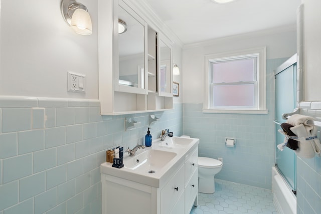 293 Grove St, Charleston, SC 29403 - bathroom featuring tile walls, double vanity, tile patterned flooring, toilet, and bath / shower combo with glass door