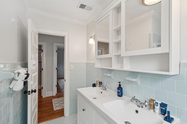 293 Grove St, Charleston, SC 29403 - bathroom with tile walls, crown molding, double vanity, and a wainscoted wall