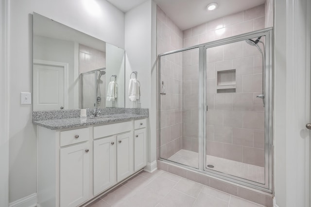 bathroom featuring walk in shower, vanity, and tile patterned flooring