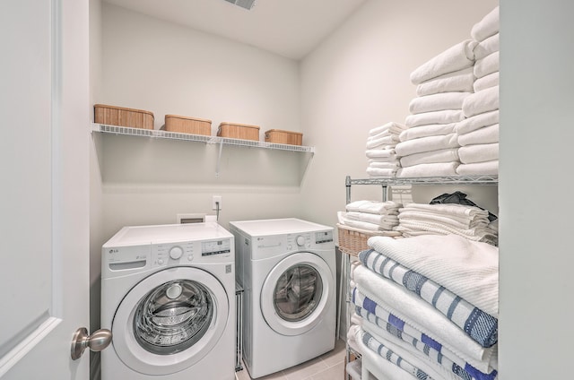 laundry area featuring light tile patterned floors and washing machine and dryer