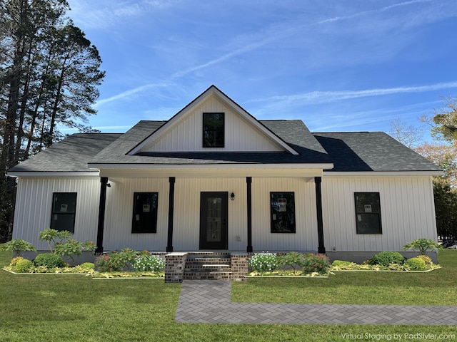 modern farmhouse style home with covered porch and a front yard