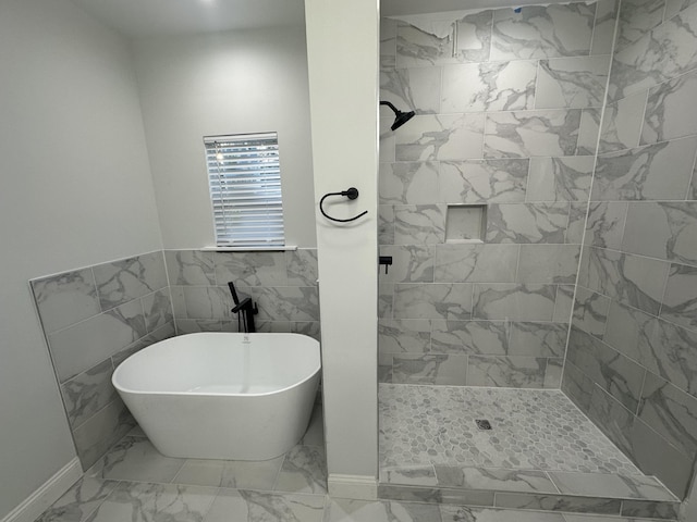 bathroom with shower with separate bathtub and tile walls