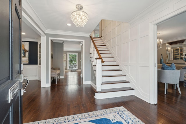 entrance foyer with stairway, an inviting chandelier, ornamental molding, and a decorative wall