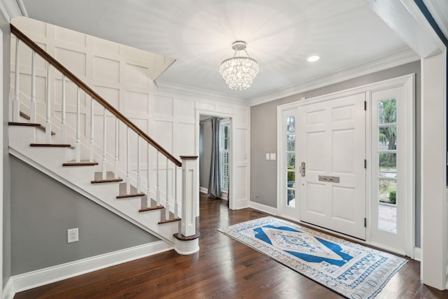 entryway featuring dark wood-type flooring, ornamental molding, and stairs