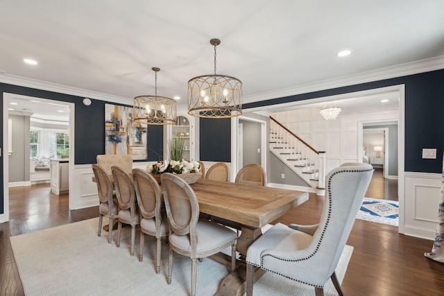 dining area featuring dark wood-style flooring, crown molding, and a decorative wall