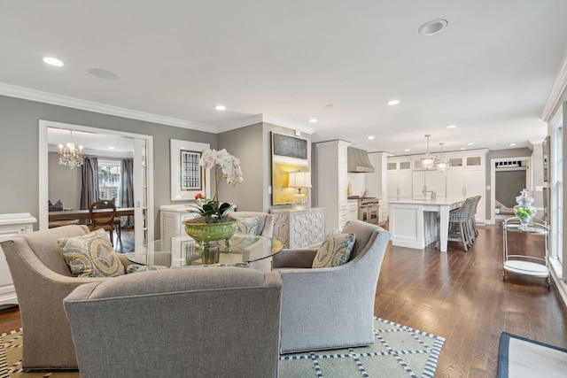 living room with a chandelier, recessed lighting, ornamental molding, and dark wood-style flooring