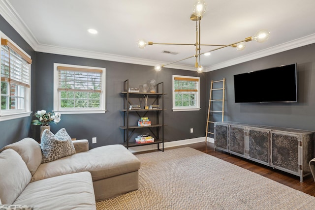 living area with visible vents, baseboards, wood finished floors, and crown molding