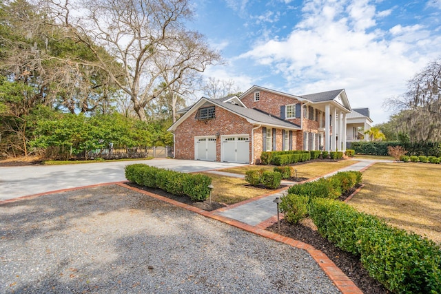 view of front of home featuring driveway, fence, a front yard, a garage, and brick siding