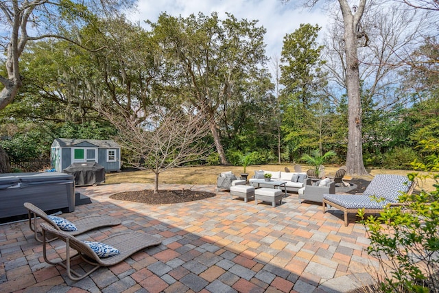 view of patio featuring a hot tub, outdoor lounge area, an outdoor structure, area for grilling, and a storage unit