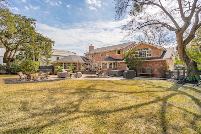 rear view of property with a yard, a hot tub, a patio, and fence