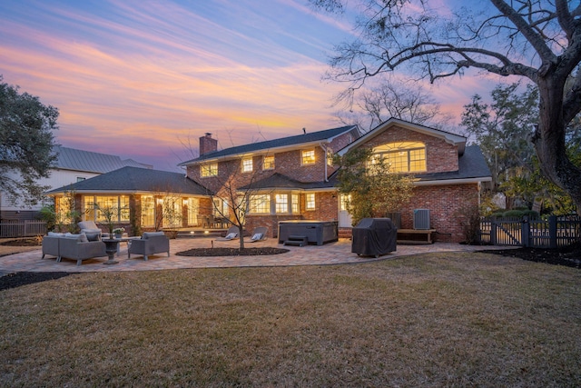 rear view of house featuring a patio area, fence, a yard, and a hot tub