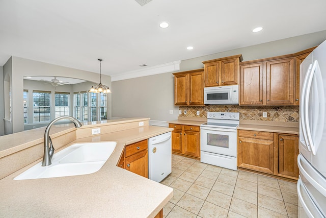 kitchen featuring light countertops, white appliances, a sink, and decorative backsplash