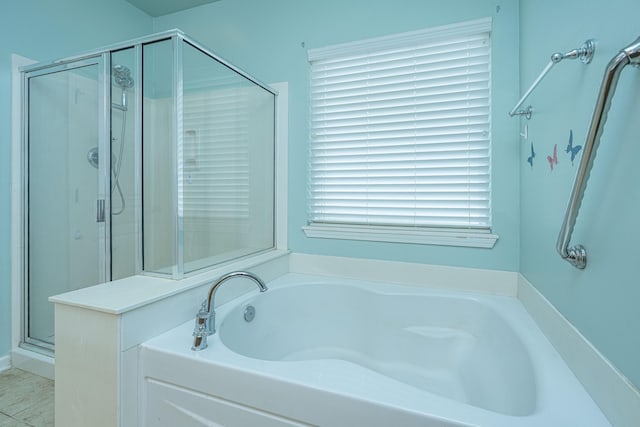 bathroom with a stall shower and a garden tub