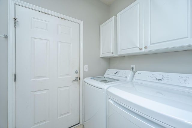 laundry room with washing machine and dryer and cabinet space