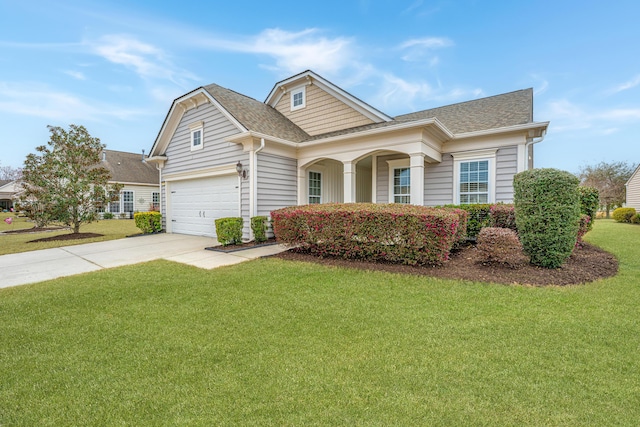 view of front of property with a garage, concrete driveway, a shingled roof, and a front yard