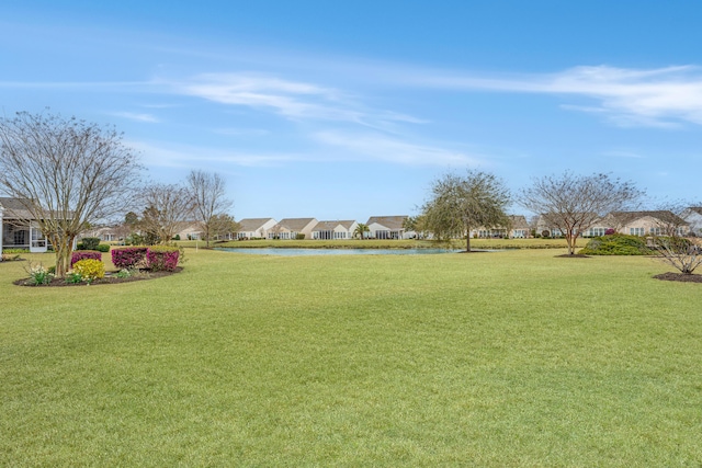 view of property's community with a residential view and a lawn