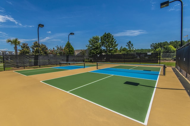 view of tennis court with community basketball court and fence