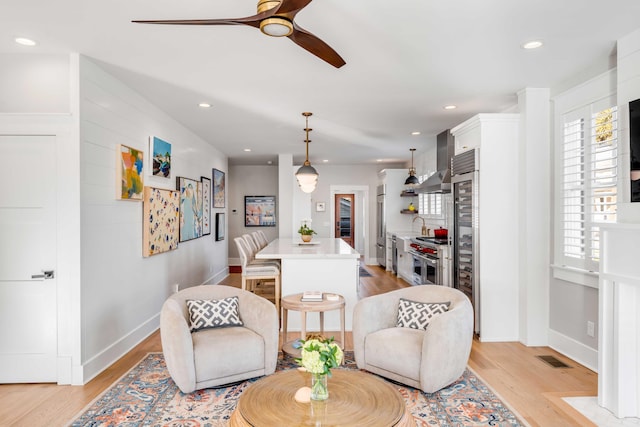 sitting room with light wood-style floors, recessed lighting, ceiling fan, and baseboards