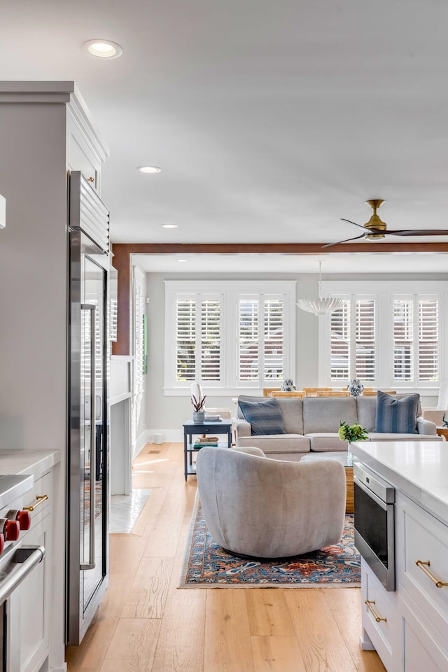 living area with ceiling fan, baseboards, light wood-style flooring, and recessed lighting