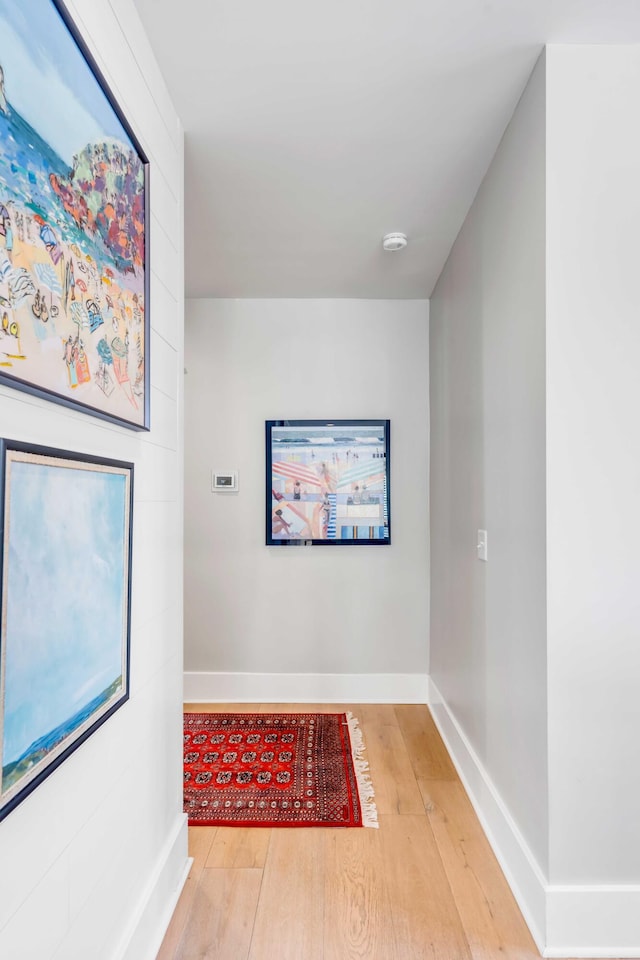 corridor with wood finished floors and baseboards