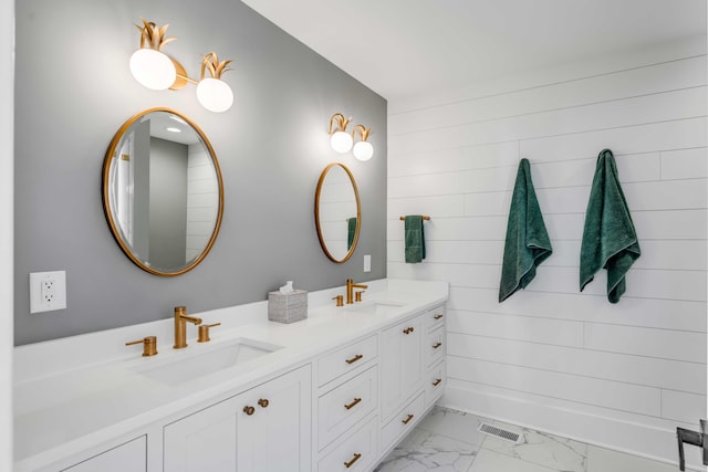 full bath with double vanity, marble finish floor, visible vents, and a sink